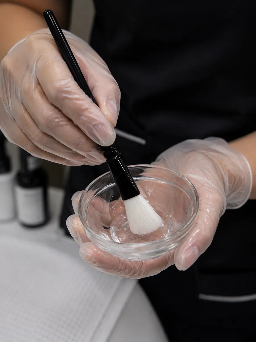 A practitioner preparing a peel solution before treatment